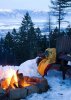 Wooden chair with blankets next a cozy fire in the snow.jpg