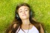 15693021-happiness-girl-with-headphones-relaxing-on-green-grass-in-the-park.jpg